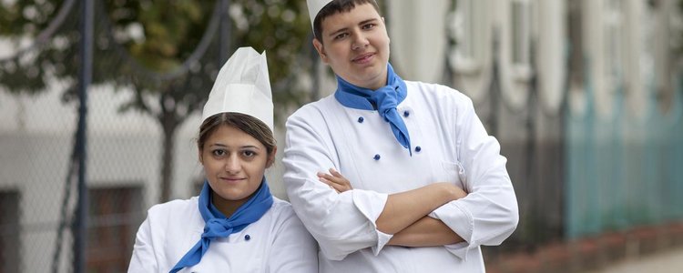 Junger Mann und junge Frau in Kochuniform